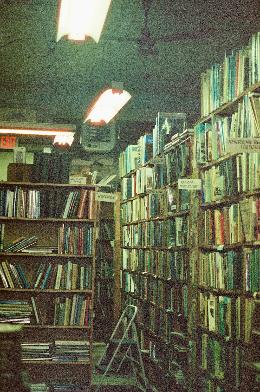 a room filled with lots of books and a ladder