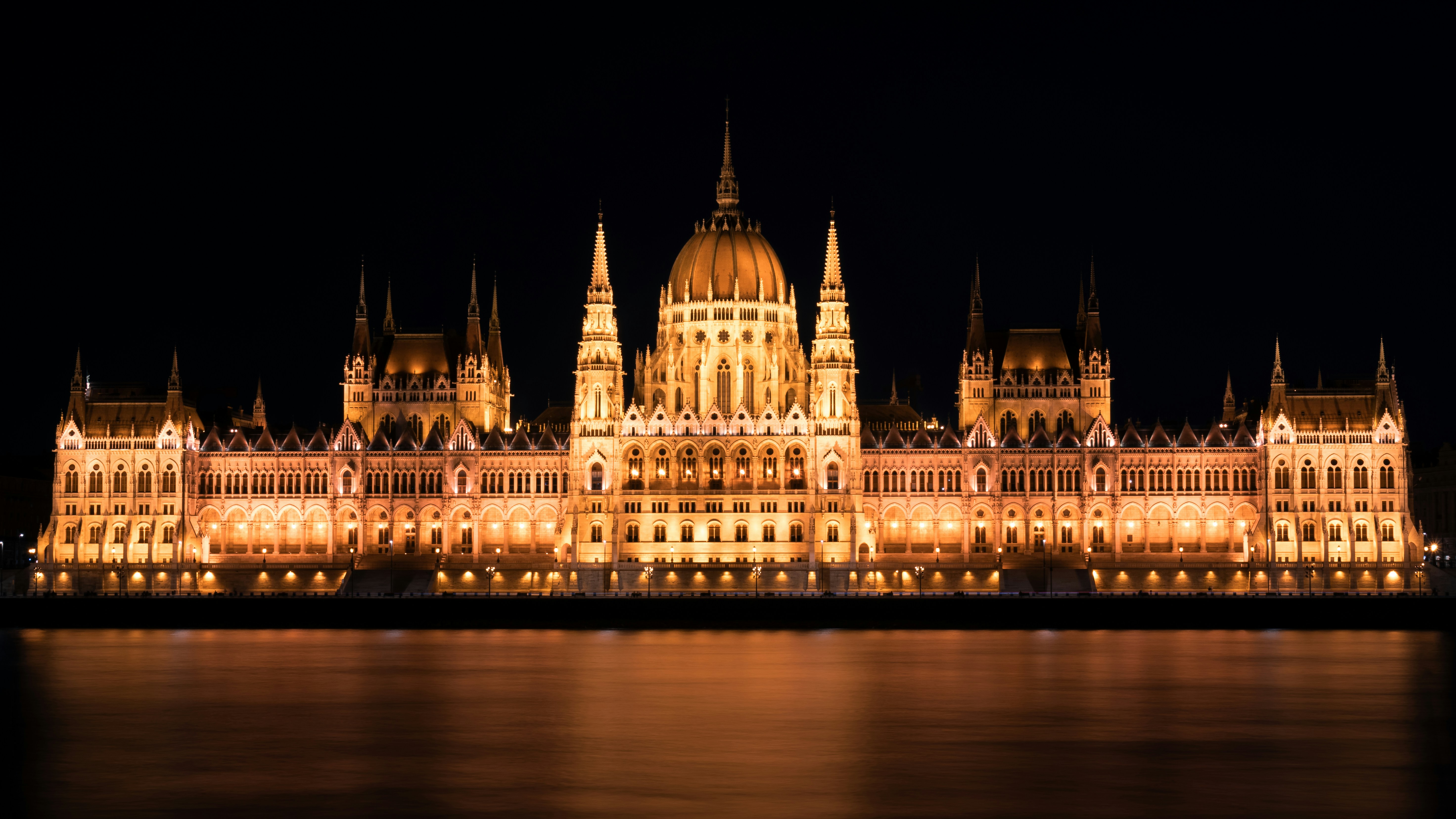 a large building lit up at night next to a body of water