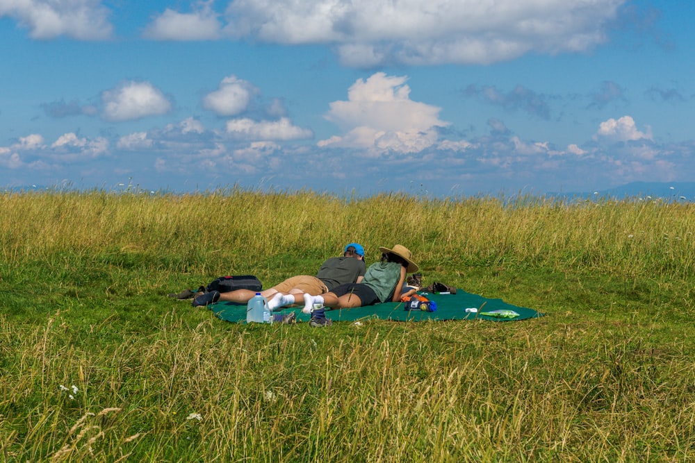 a man laying on a blanket in a field