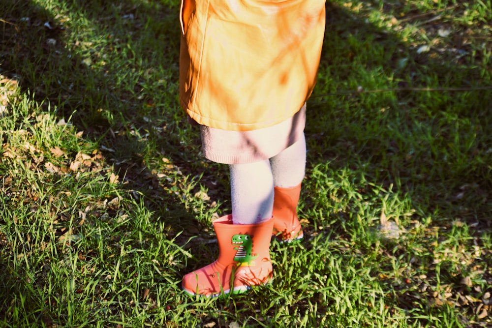 a little girl standing in the grass holding a frisbee