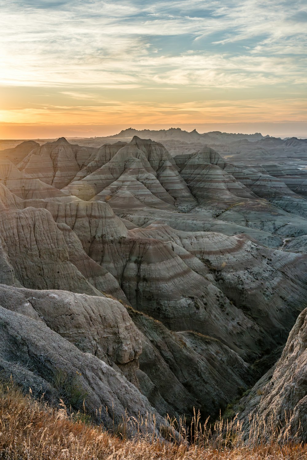 the sun is setting over the mountains in the desert