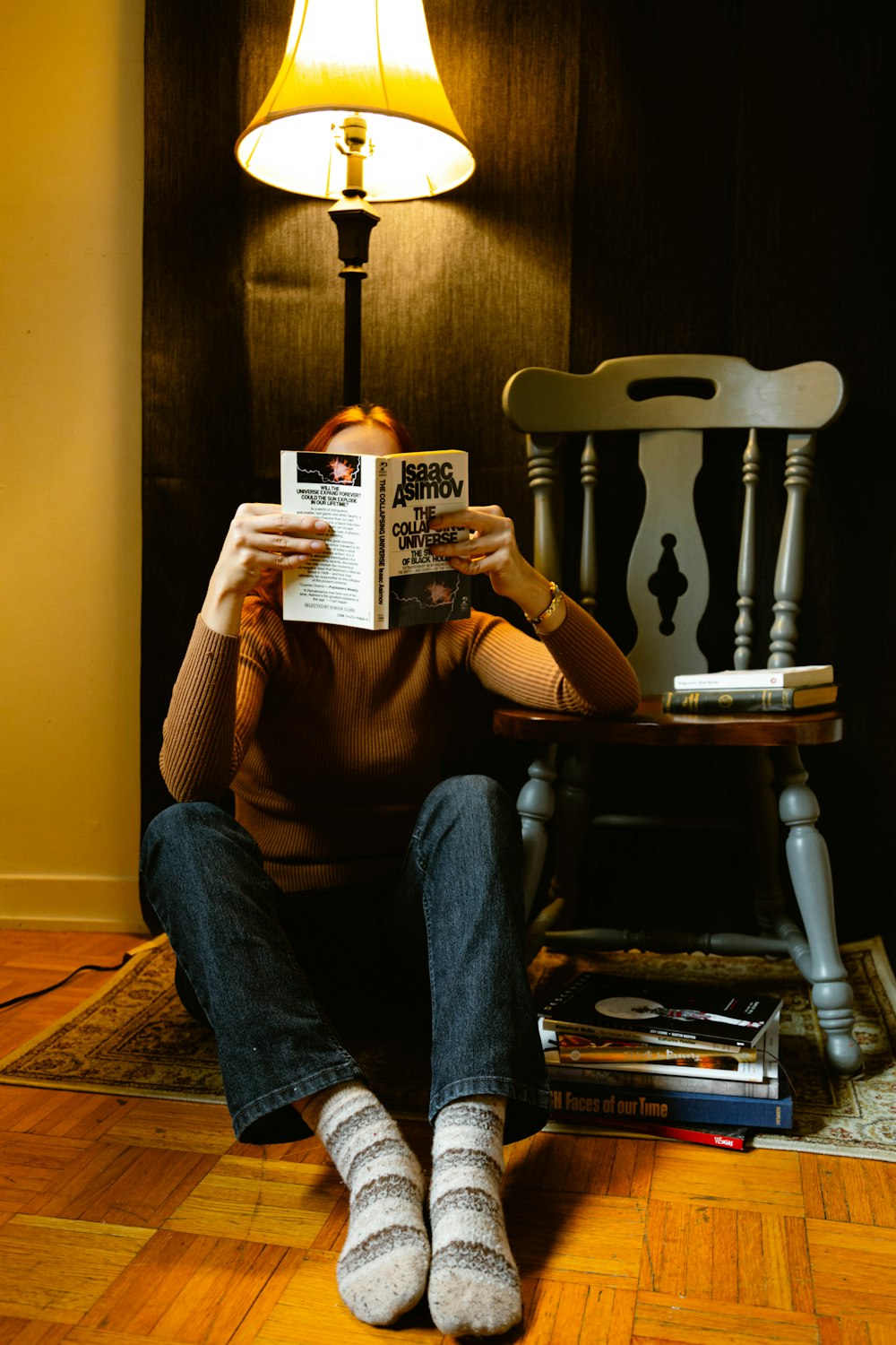 a person sitting on the floor reading a book