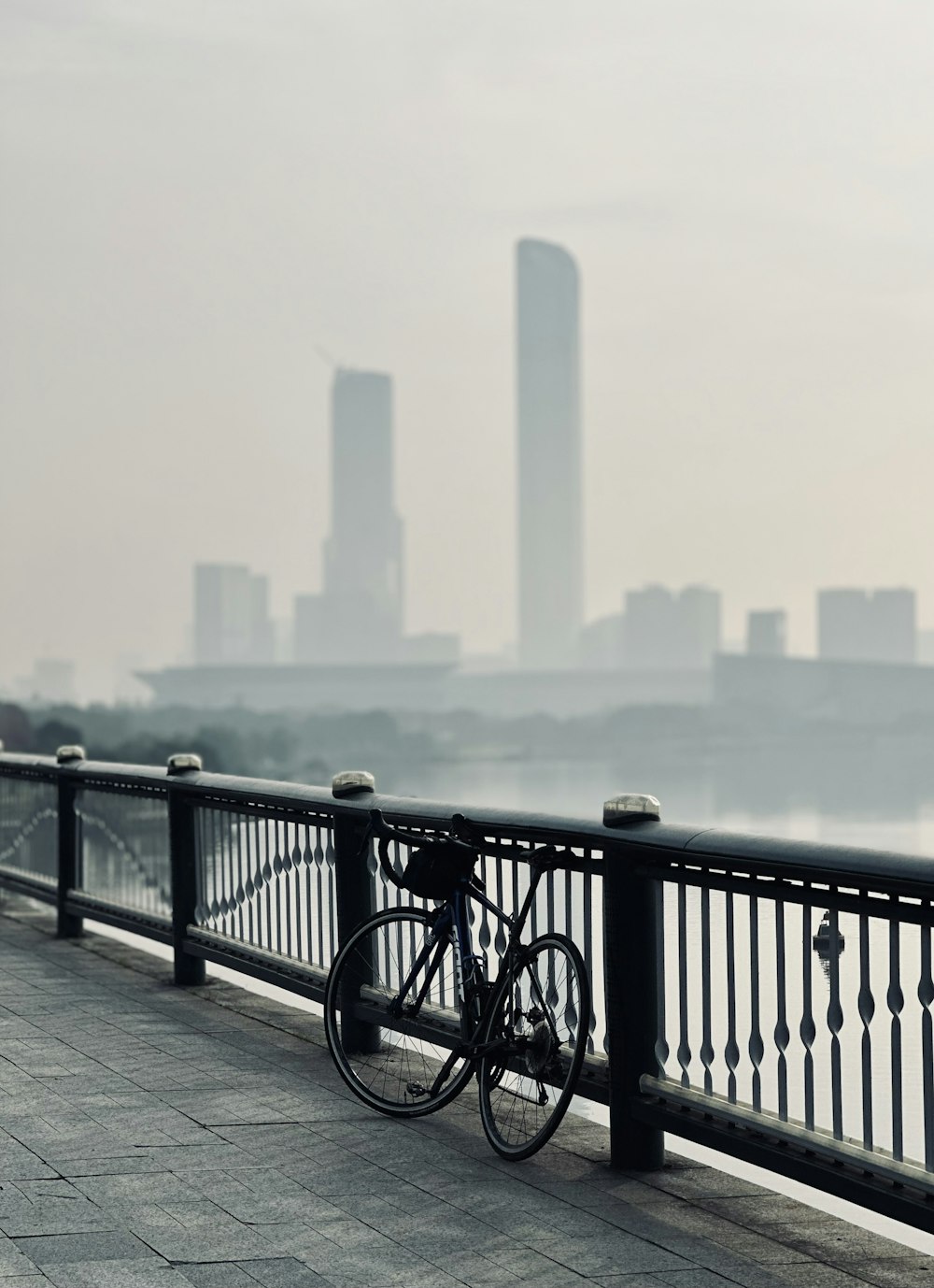 a bicycle leaning against a railing overlooking a body of water