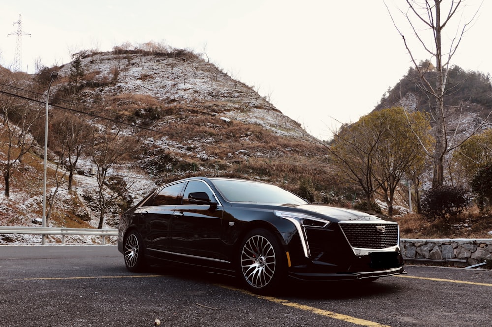 a black car parked in front of a mountain