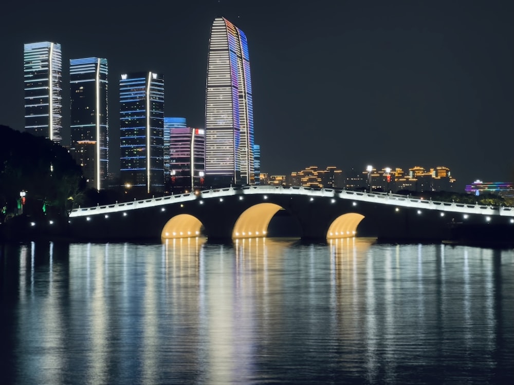 a bridge over a body of water with a city in the background