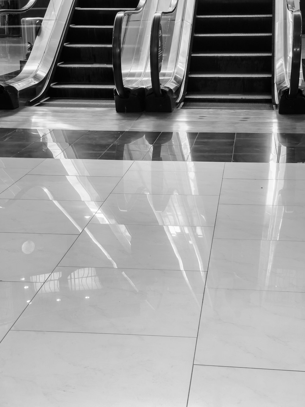 a black and white photo of escalators and stairs