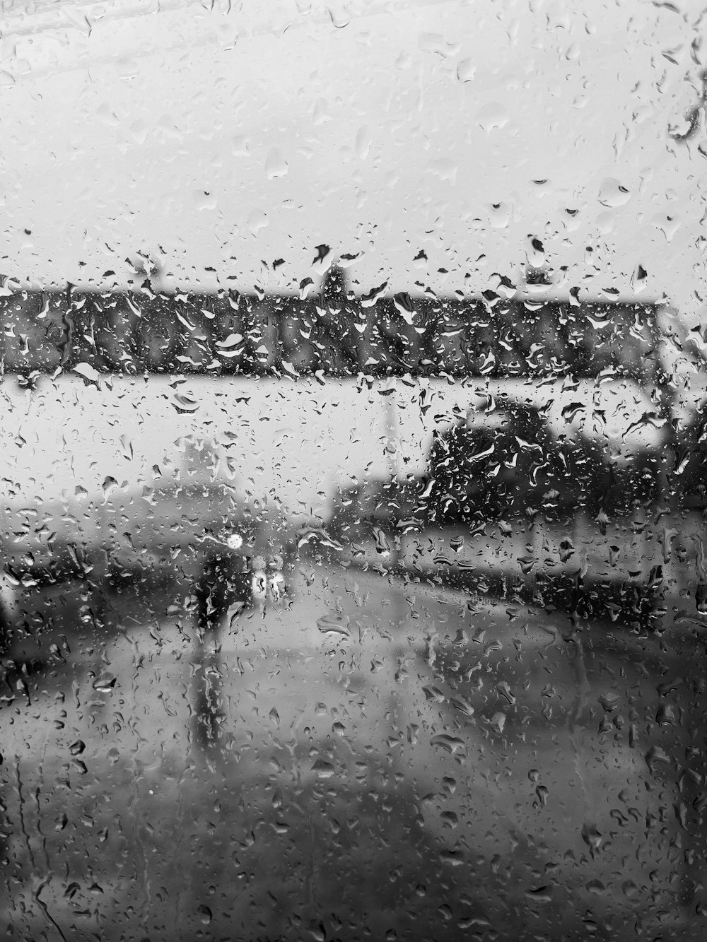 a black and white photo of a rain covered window