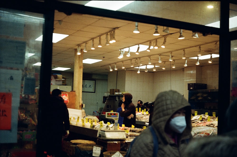 un groupe de personnes debout devant la vitrine d’un magasin