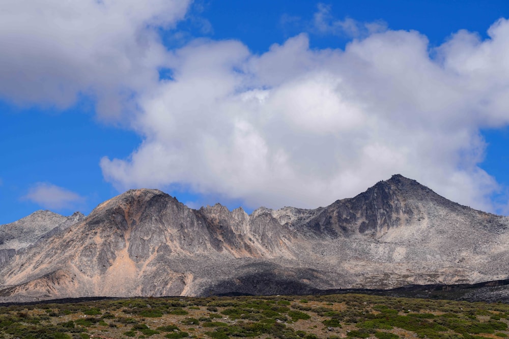 a mountain range with a few clouds in the sky