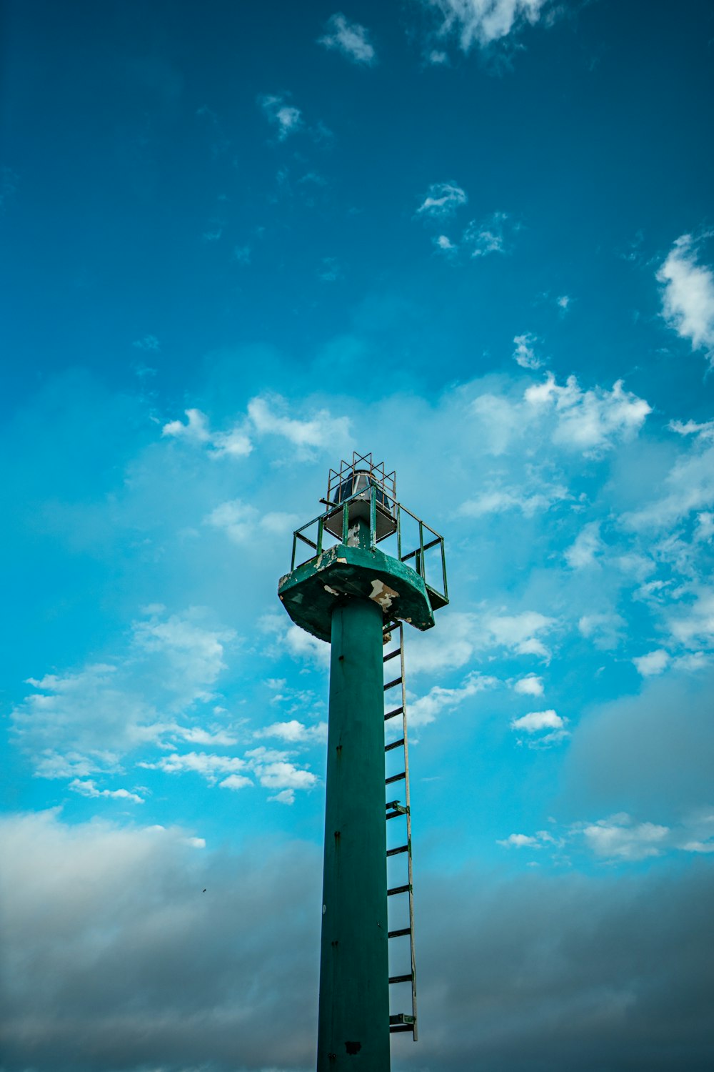 a tall green tower with a sky background