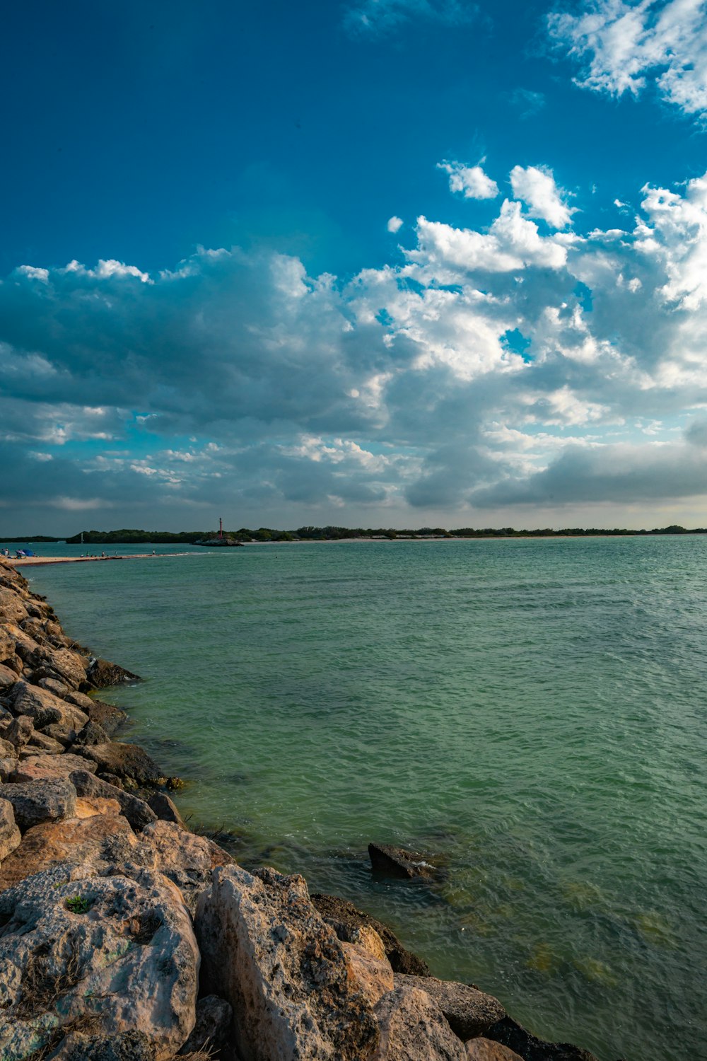 a large body of water sitting next to a rocky shore