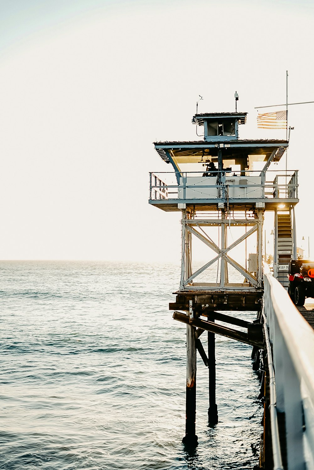 ein Rettungsschwimmerturm, der auf einem Pier neben dem Meer sitzt