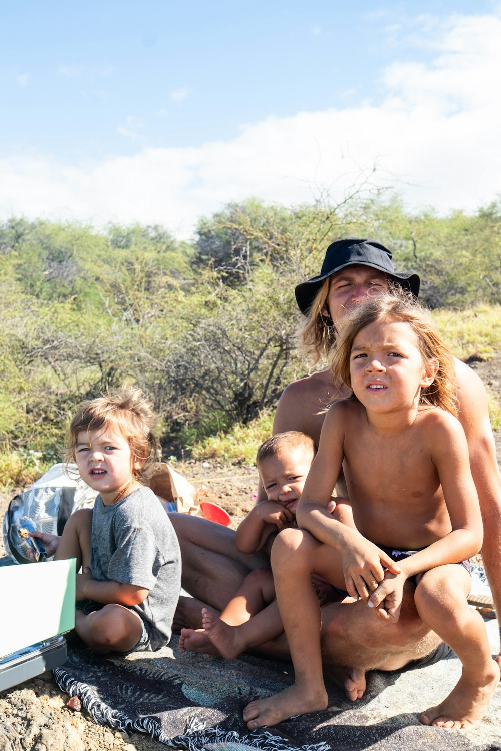 a group of kids sitting on a rock together