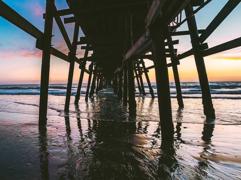 a view of a pier from the water at sunset