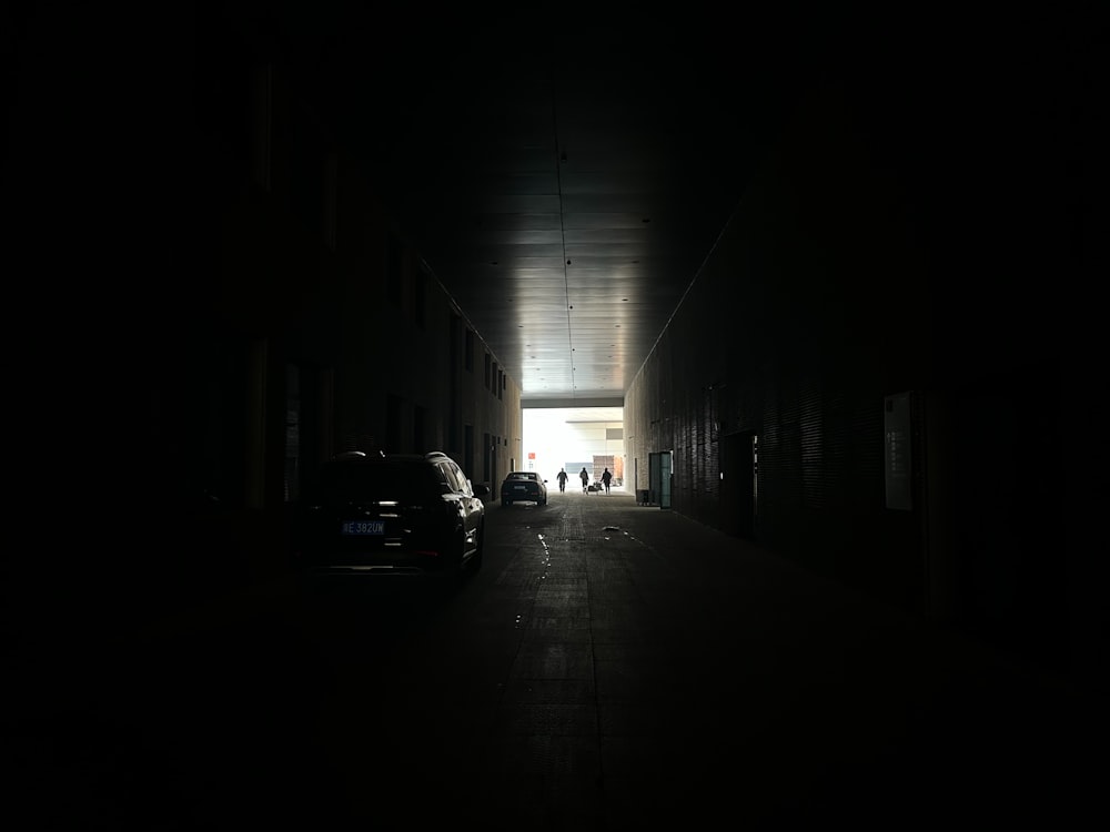 a dark hallway with cars parked in it