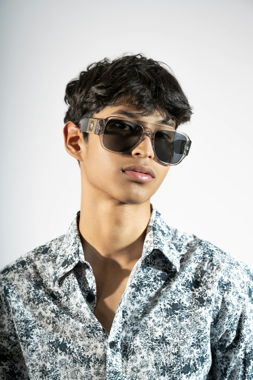 a young man wearing sunglasses and a shirt