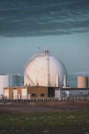 a large white building sitting on top of a grass covered field