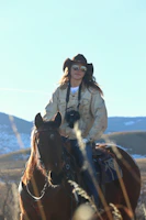 a woman riding on the back of a brown horse