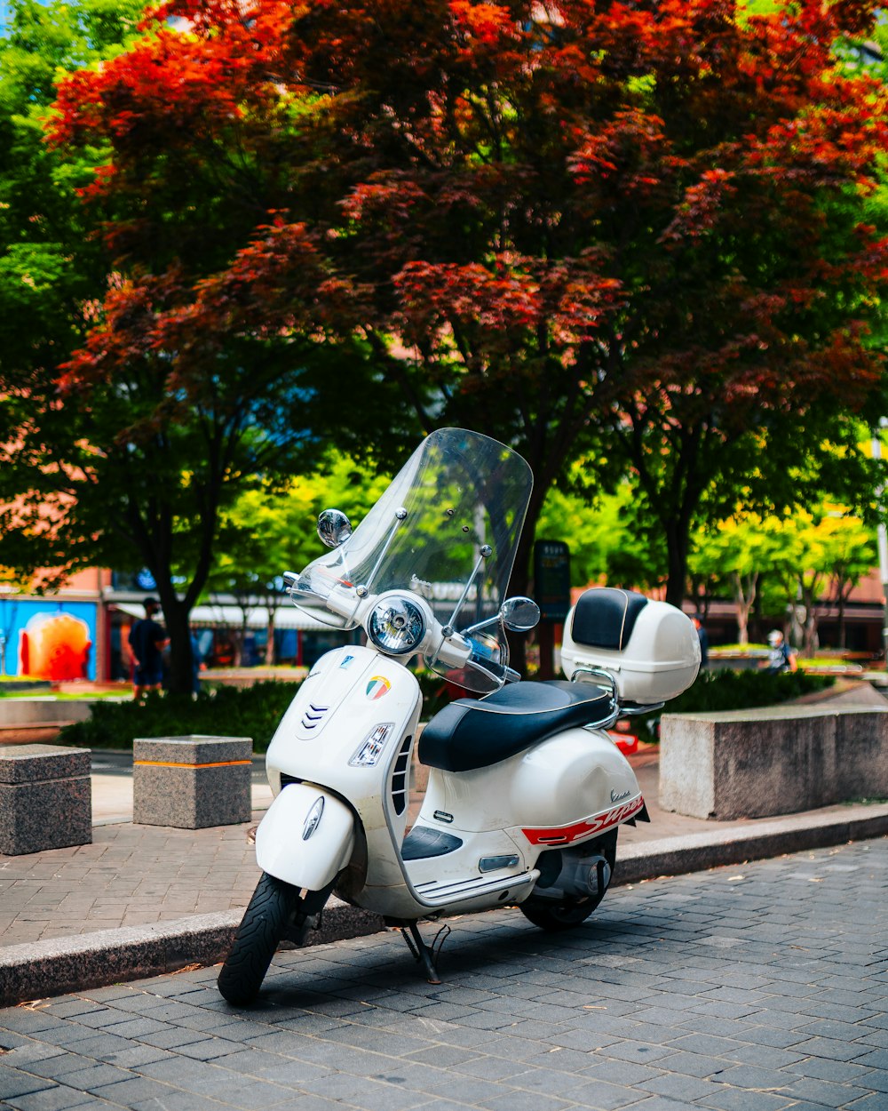 uma scooter branca estacionada na beira da estrada