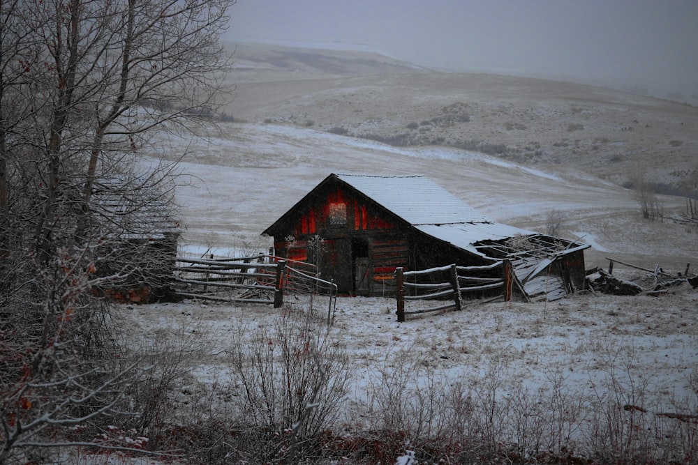 a barn in the middle of a snowy field