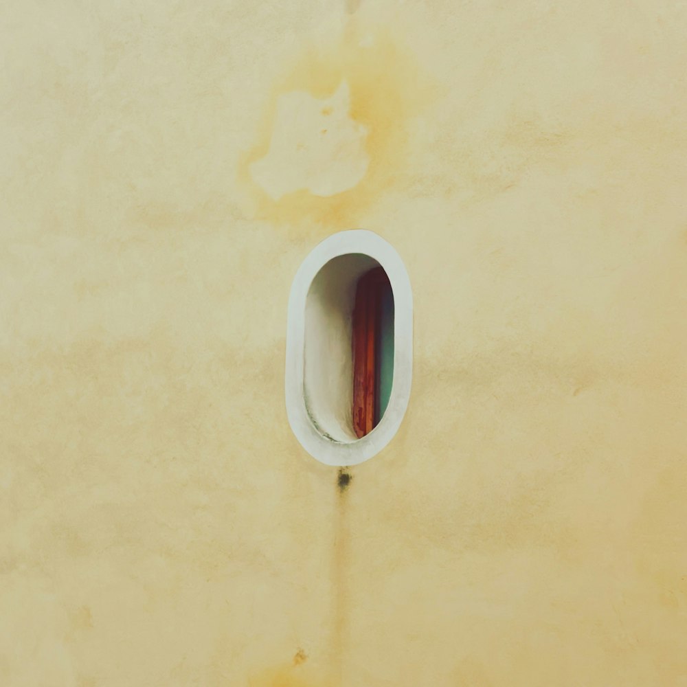 a wall with a hole in it with a toothbrush in it