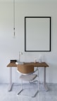 a desk with a chair and a picture hanging on the wall