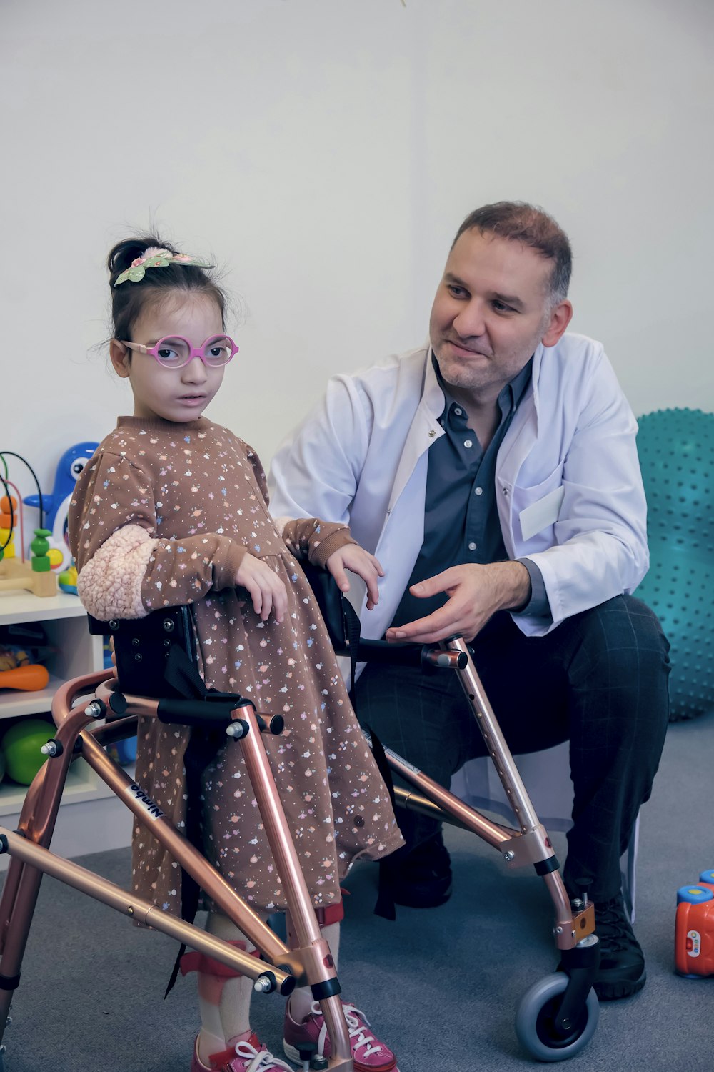 Ein Mann sitzt neben einem kleinen Mädchen auf einem Rollator