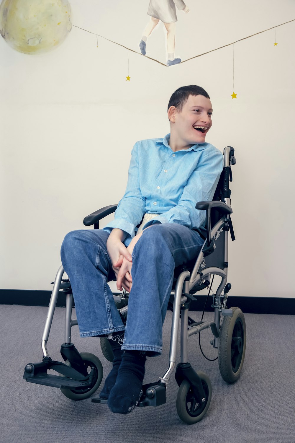 um homem sentado em uma cadeira de rodas em uma sala