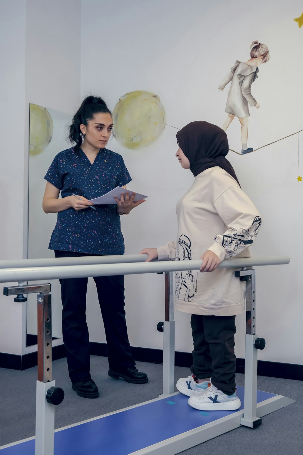 a woman standing next to a woman on a treadmill