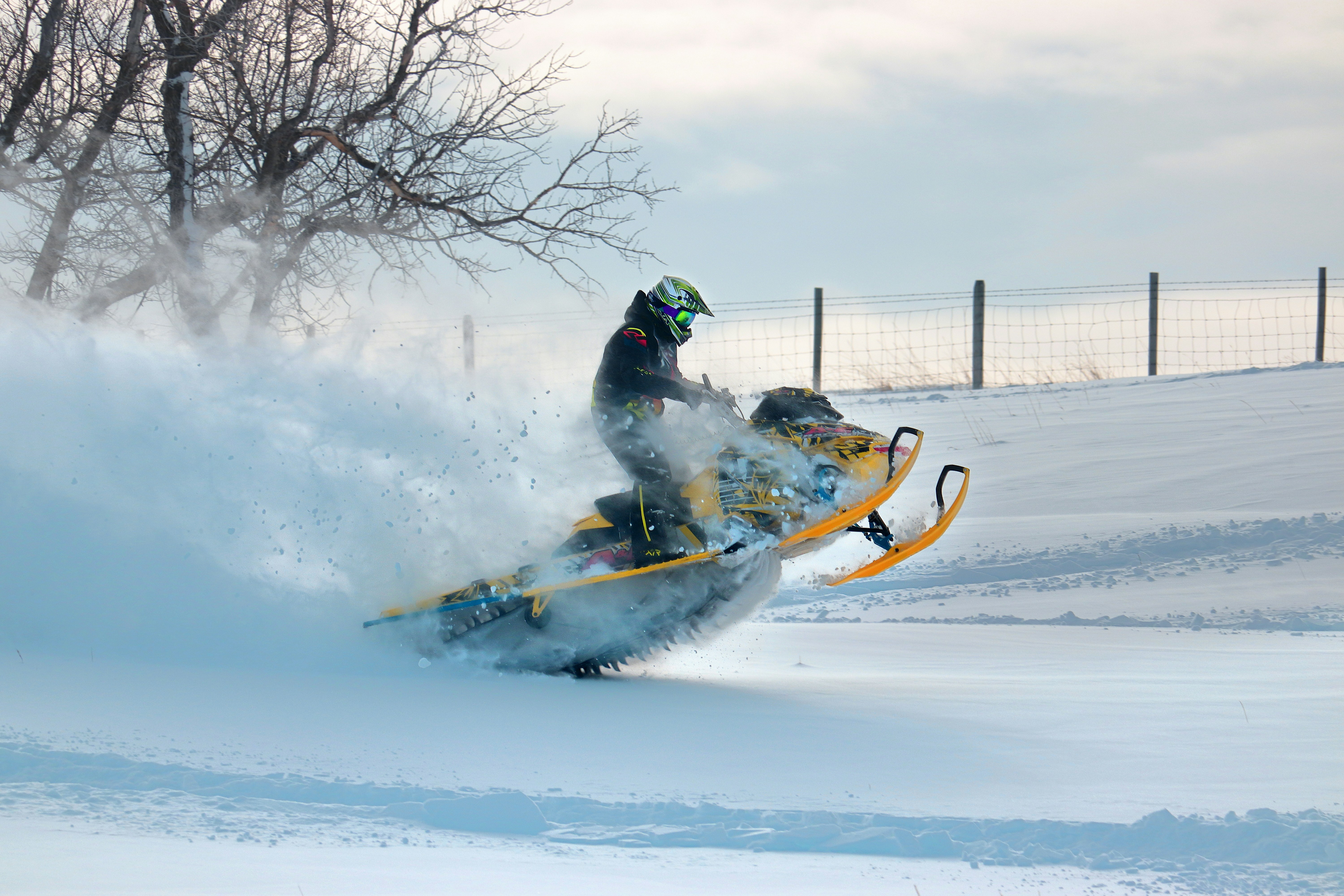 A man riding a snowmobile down a snow covered slope photo – Free Man ...