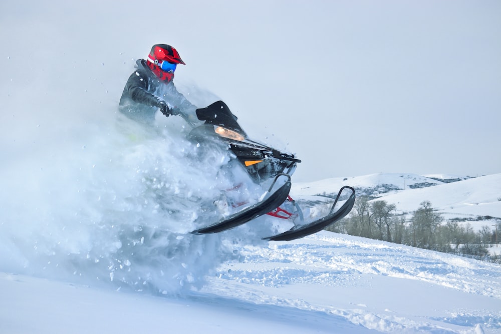 uma pessoa montando um snowmobile na neve