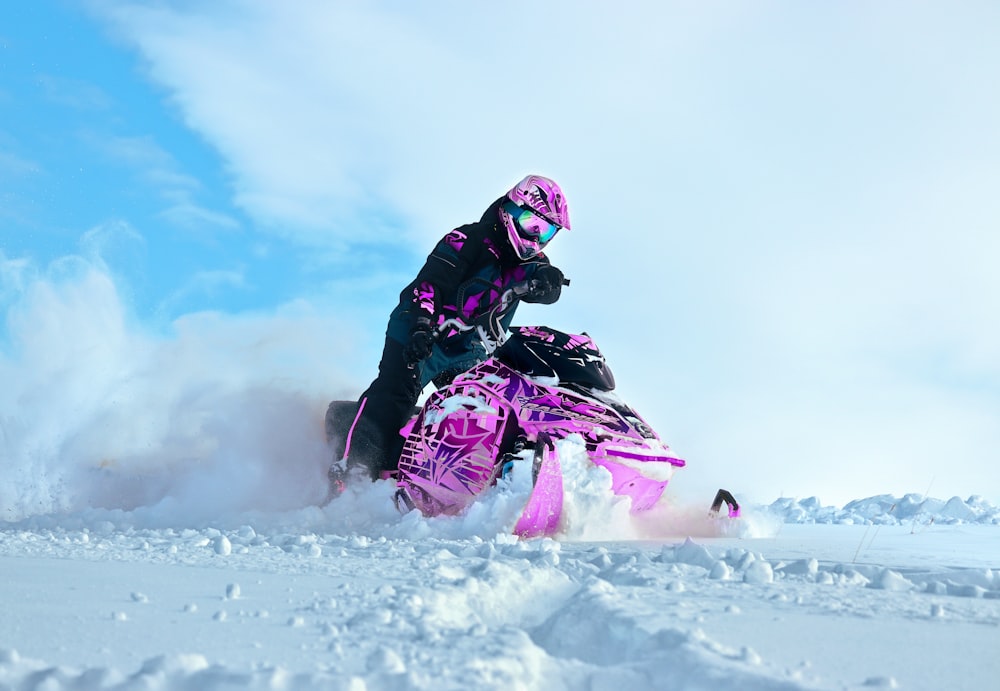 uma pessoa montando um snowmobile na neve