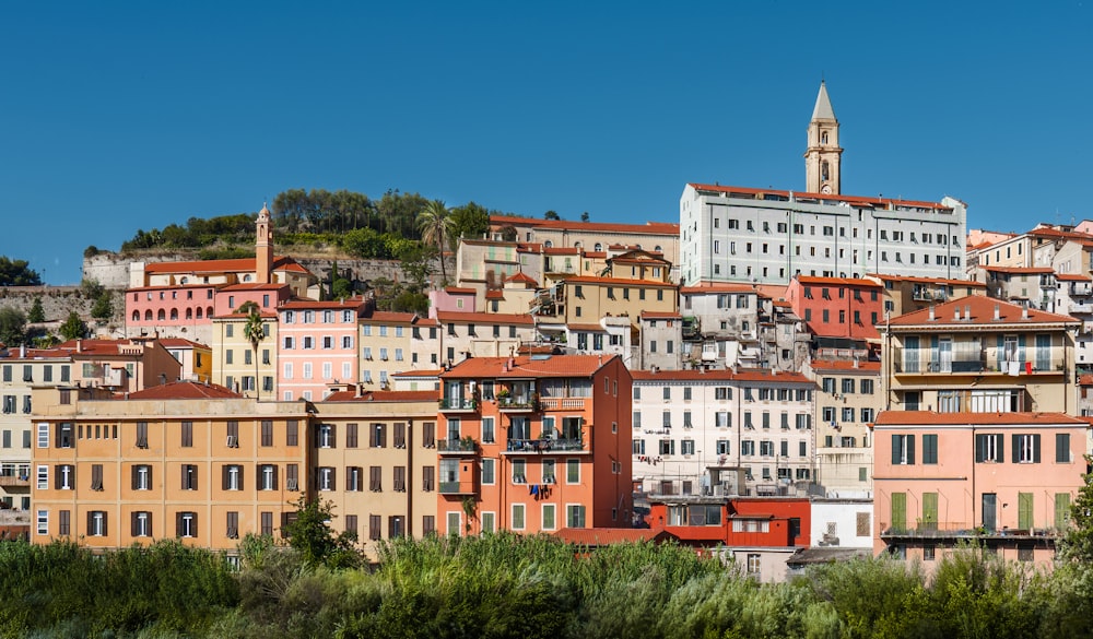 a group of buildings with a steeple in the background