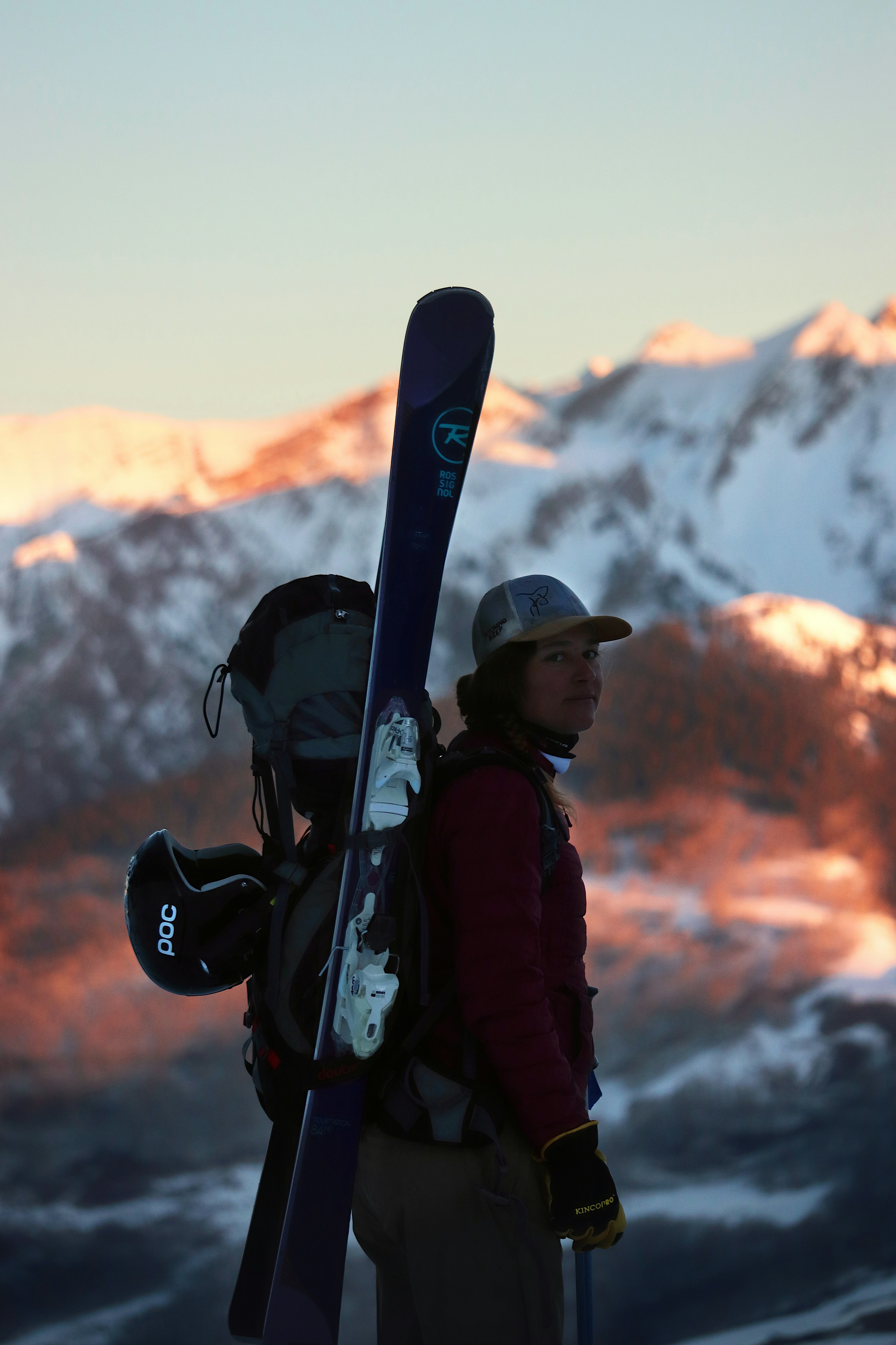 a man holding a pair of skis on top of a snow covered mountain