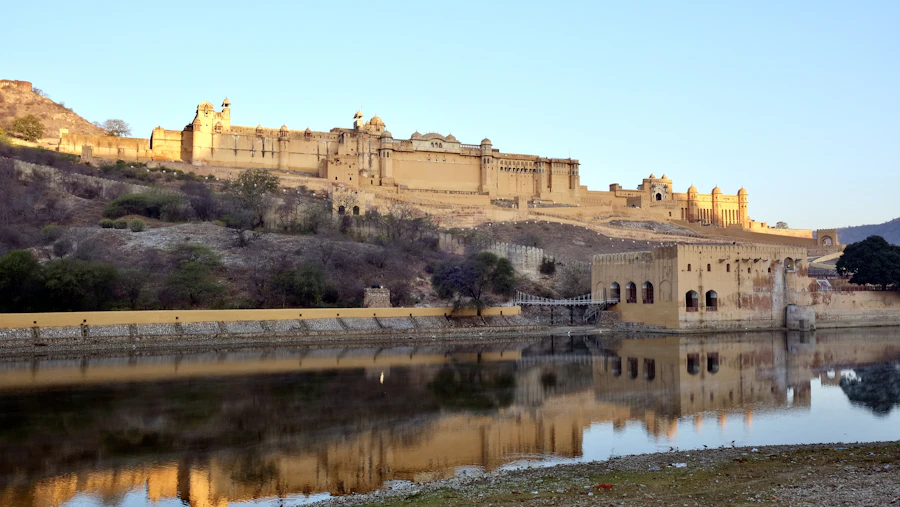 Amber Fort in Jaipur reflected in the water of Maota Lake at sunrise