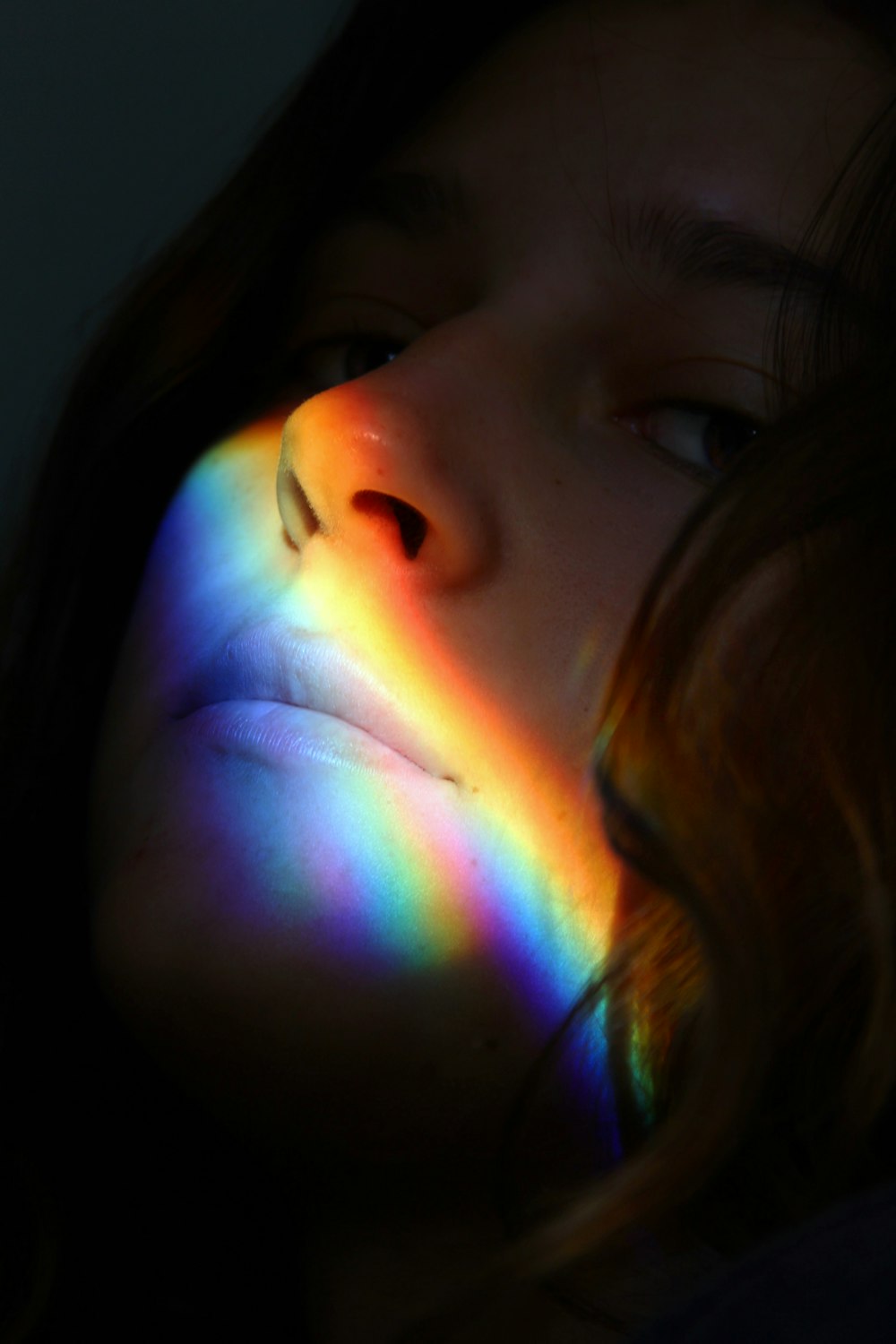 a woman with a rainbow light on her face
