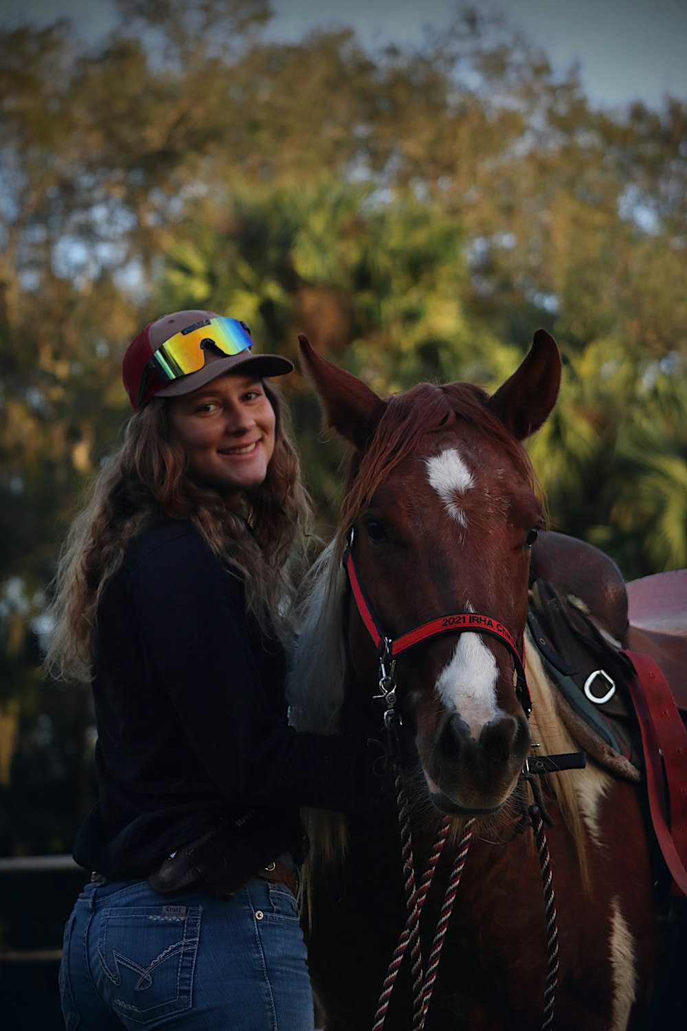 a woman standing next to a brown and white horse