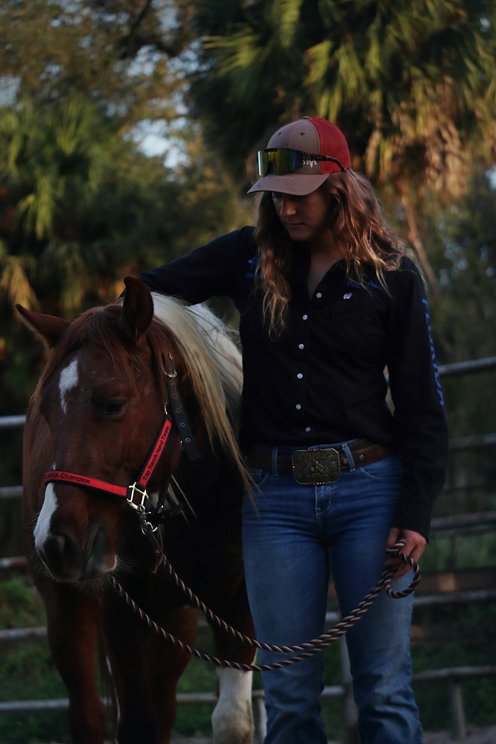 a woman standing next to a brown and white horse