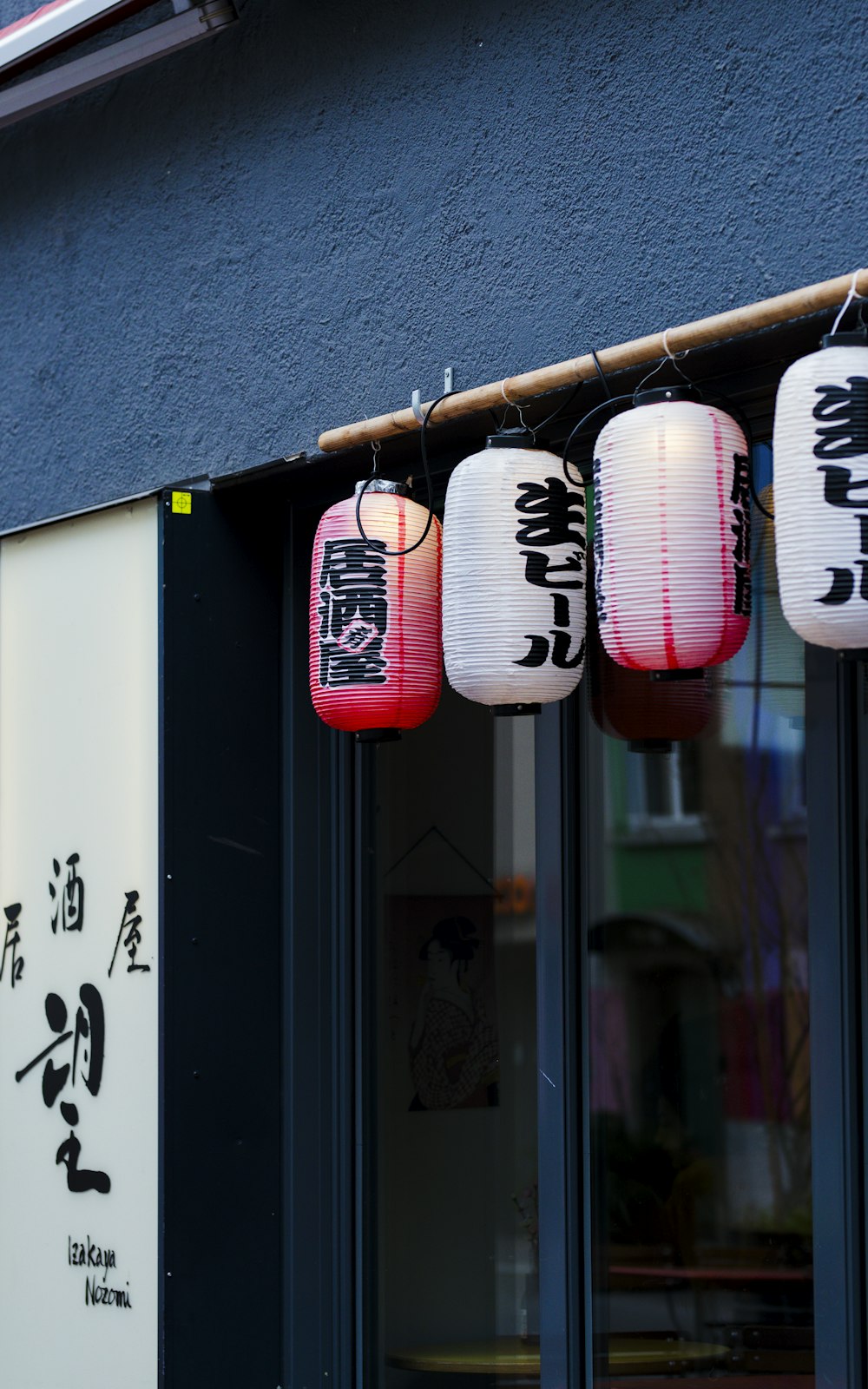 a row of lanterns hanging from the side of a building