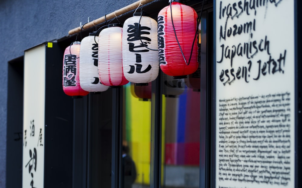 a row of lanterns hanging from the side of a building