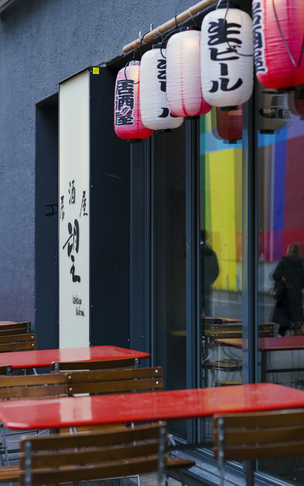 a row of red and white lanterns hanging from the side of a building