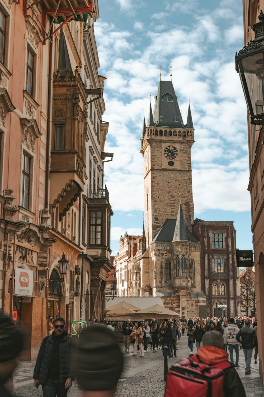 a crowd of people walking down a street next to tall buildings