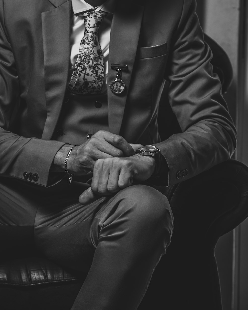 a man in a suit and tie sitting on a chair