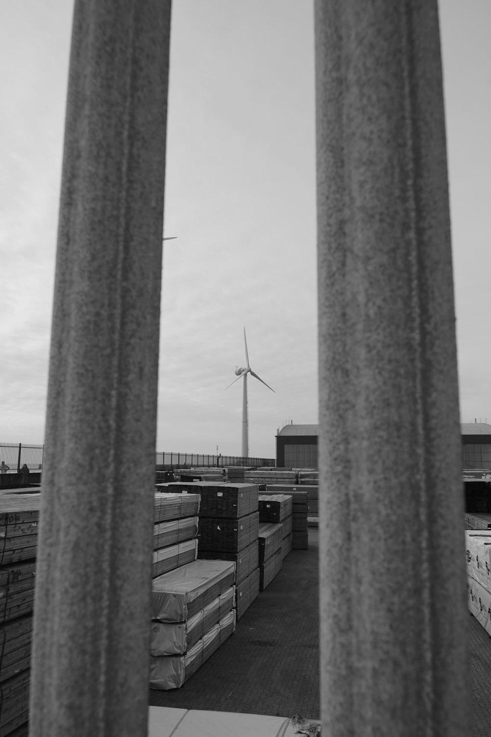 a black and white photo of a wind turbine in the distance