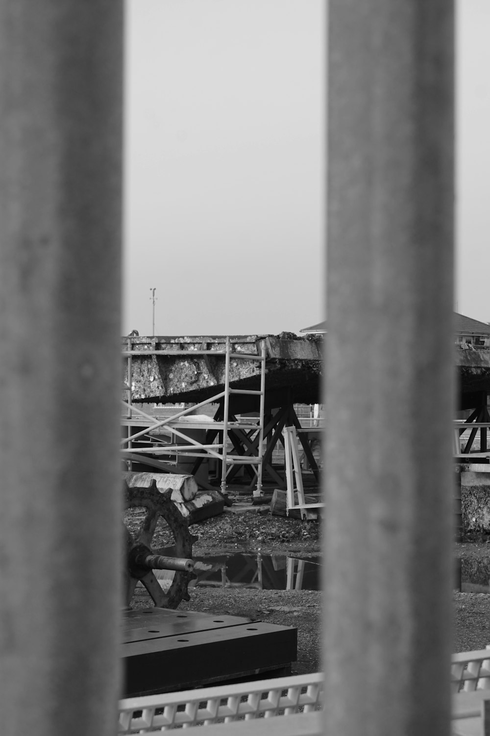 a black and white photo of a fence and a building