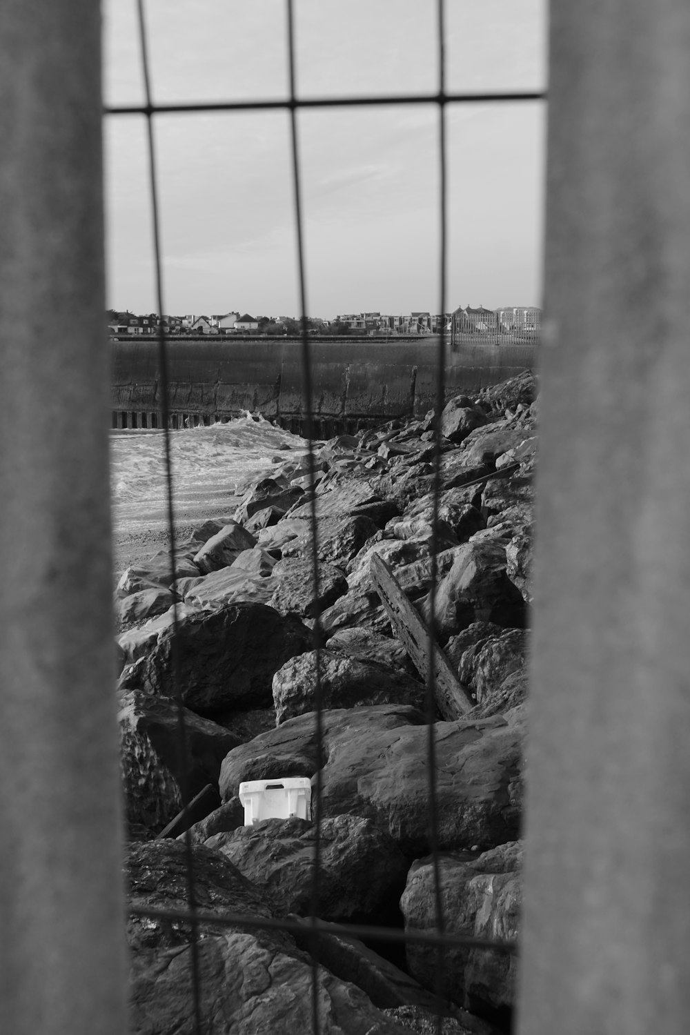 a black and white photo of rocks and a fence