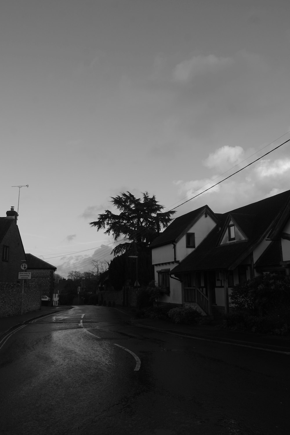 a black and white photo of a street with houses