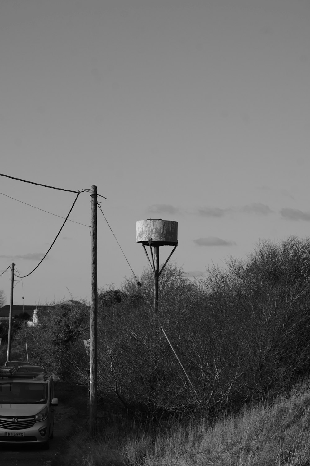 a black and white photo of a truck and a water tower