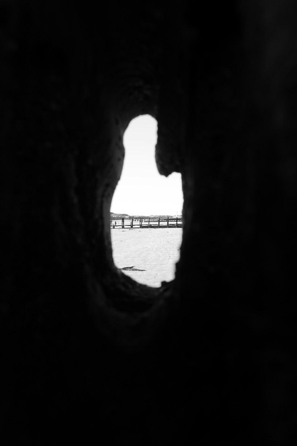 a view of a bridge through a hole in a rock