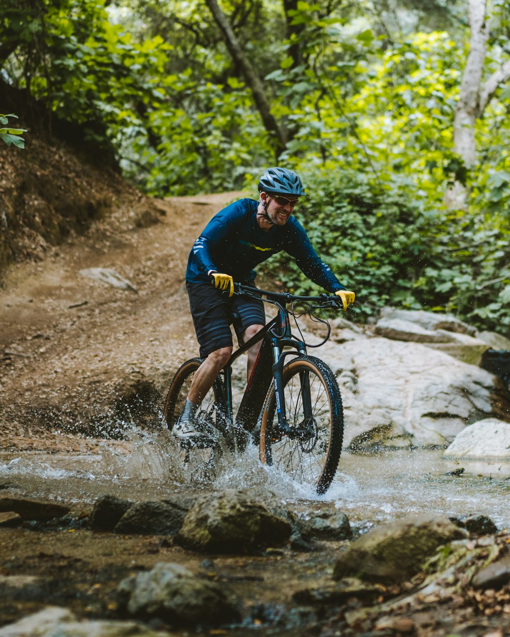 a man riding a bike through a creek